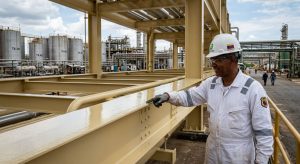 Ingeniero especialista en pintura anticorrosiva inspeccionando una estructura metálica protegida con acabado epóxico en una planta industrial venezolana